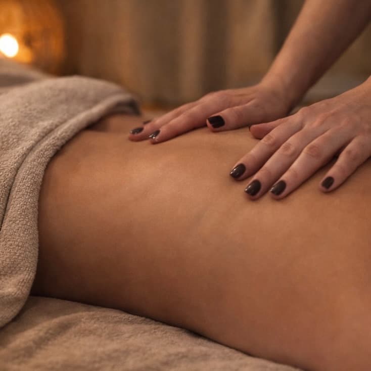 Massage sur mesure à Thionville : mains de praticienne, lumière tamisée dorée